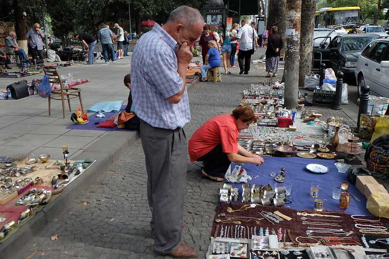 An old man shopping at a street shop