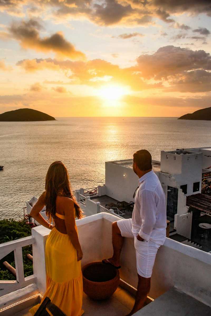 Two people watching sunset from their balcony