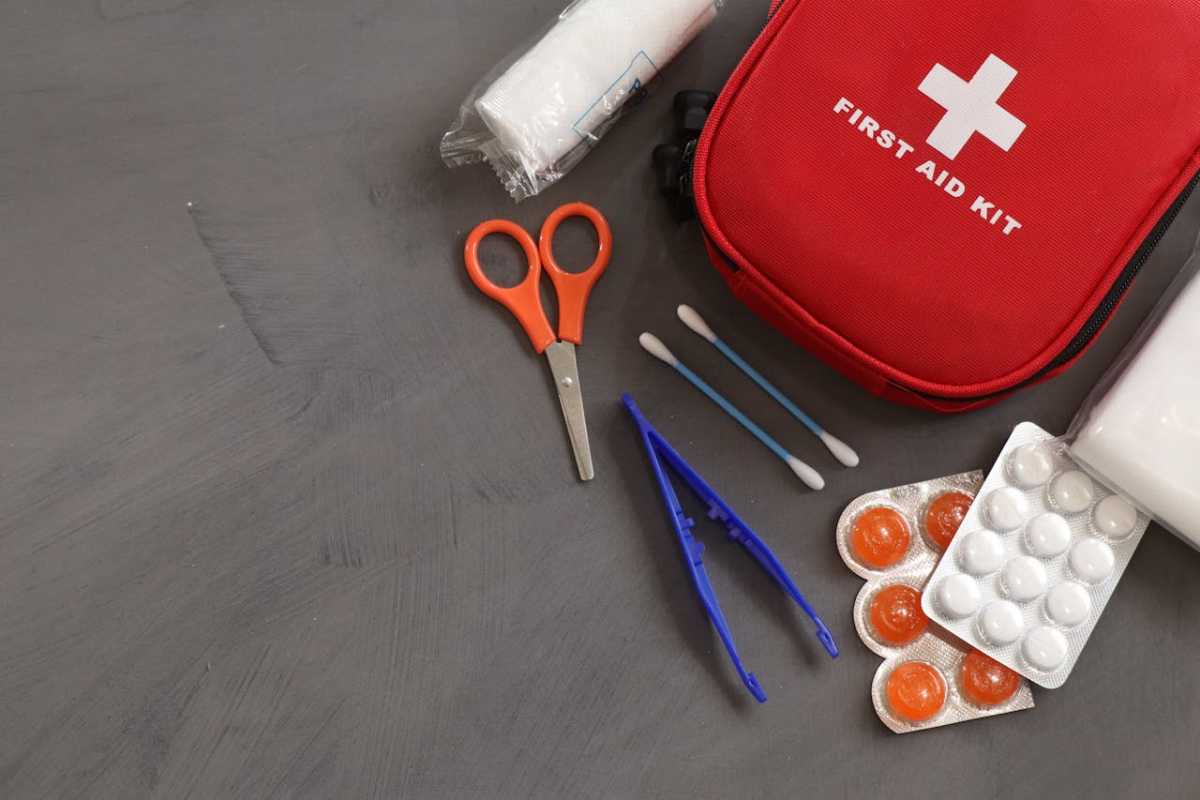 first aid kit, medicines, and equipment on grey ba